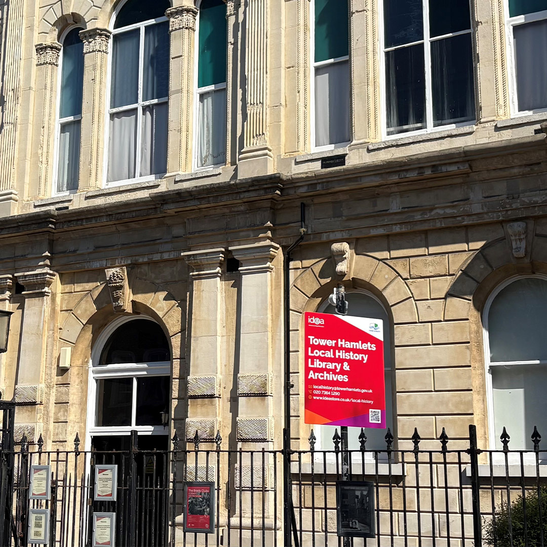 A street view of Tower Hamlets Local History Library and Archives with new signage behind railings