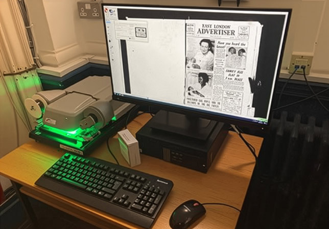 Digital microfilm reader and a computer on a desk