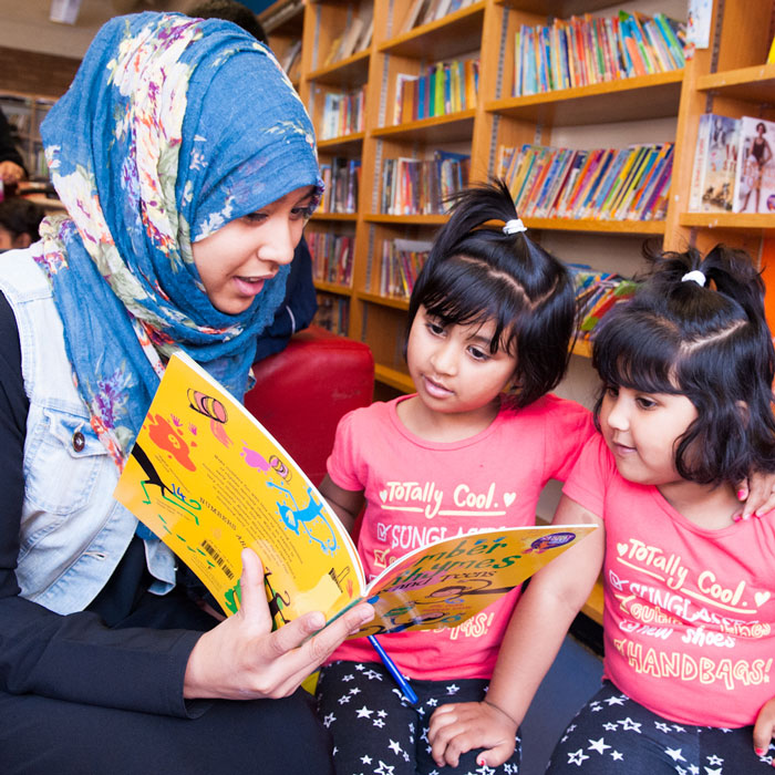 a volunteer reading to two children