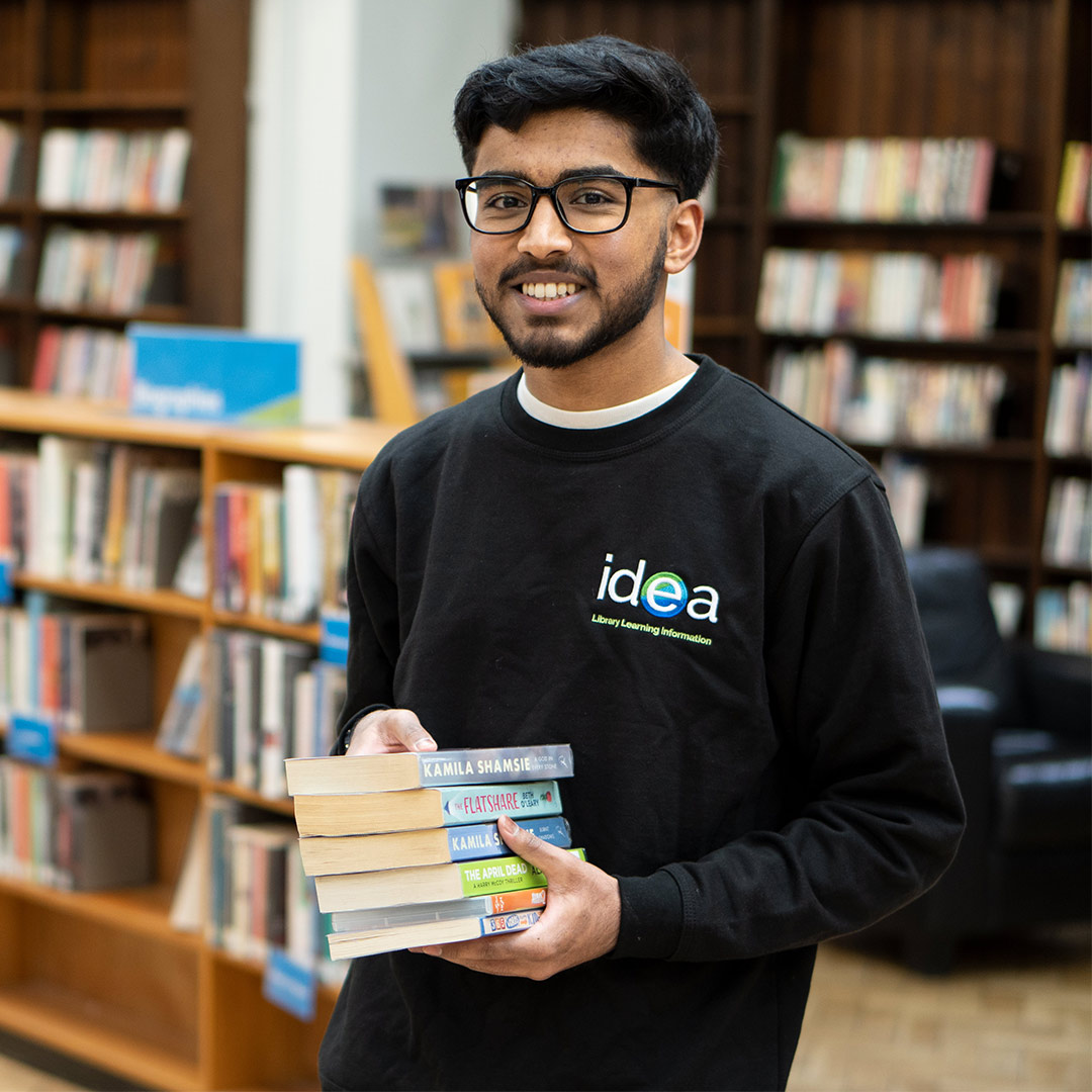 member of staff holding books