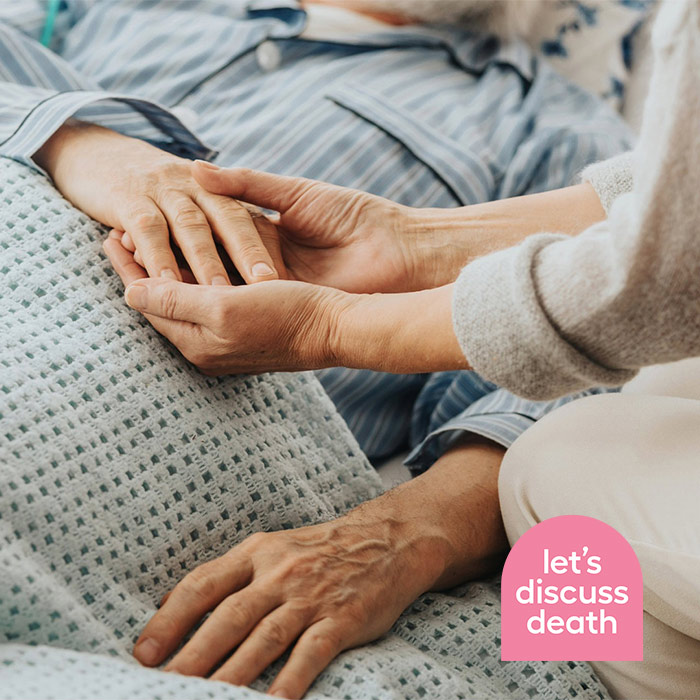 people holding hands on death bed